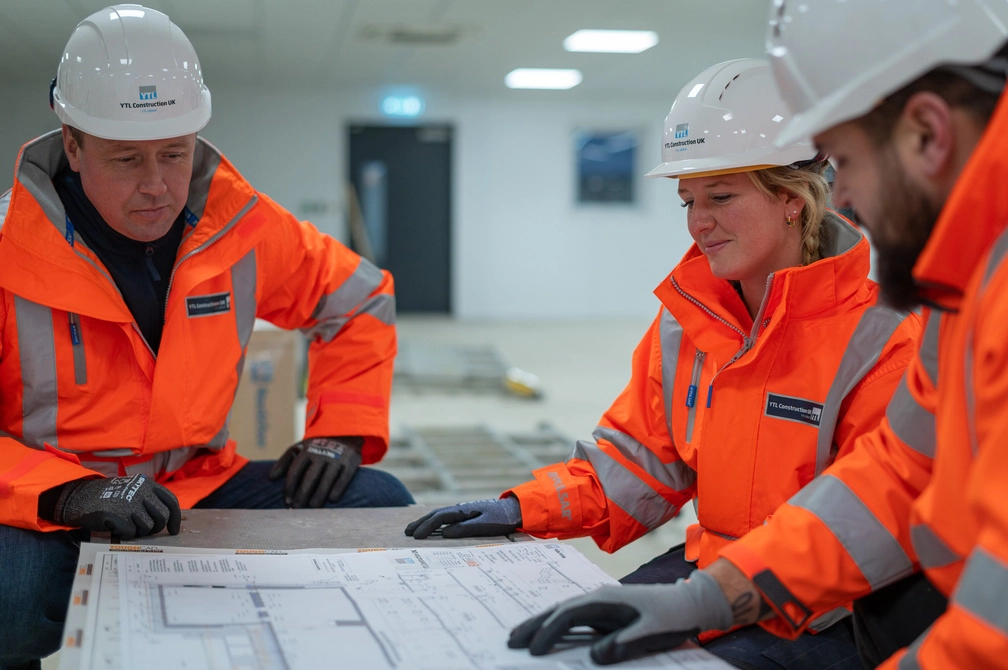 Wessex Water employees in PPE looking at construction plans