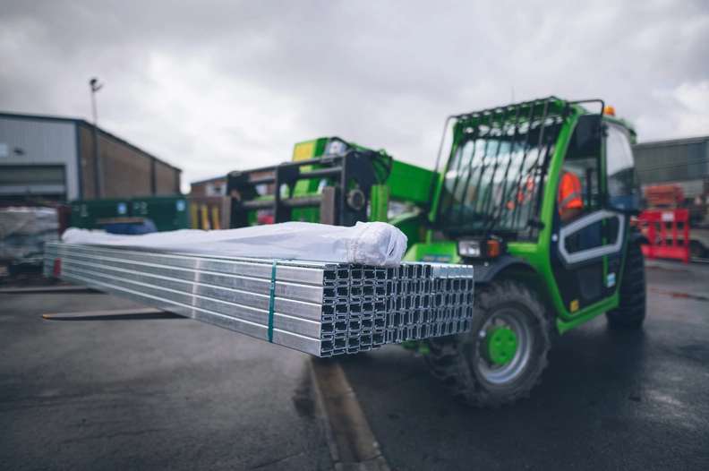 Forklift carrying metal beams