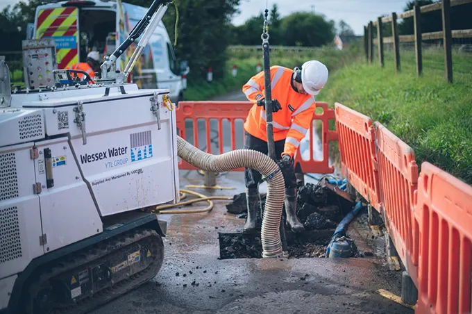 Employee repairing a water pipe in the road