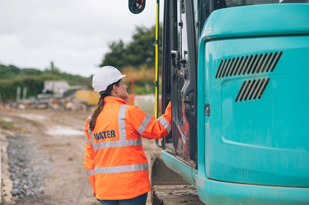 Wessex Water employee looking into digger cab