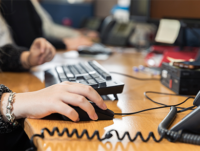 Woman sat at a desk in an office with a keyboard and mouse